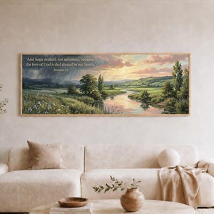 May include: A rectangular landscape wall art print featuring a river winding through a green valley at sunset. The sky shows pink and orange clouds with light rays. The text reads: 'And hope maketh not ashamed; because the love of God is shed abroad in our hearts.' Romans 5:5.