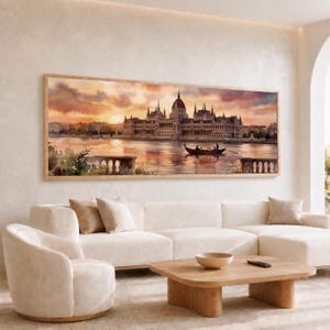 May include: A rectangular wall art print featuring a watercolor painting of the Hungarian Parliament Building at sunset. The scene depicts the grand structure along a river with a small boat in the foreground, rendered in warm orange and pink hues.