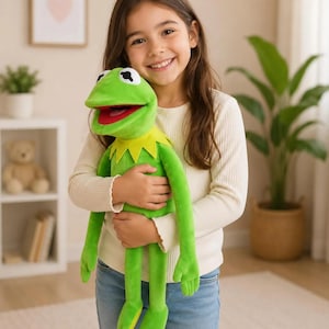May include: A bright green plush frog toy with a wide open mouth, a red interior, and a yellow pointed collar. The stuffed animal features large white eyes with black pupils and long, slender limbs, crafted from a soft, smooth fabric material.