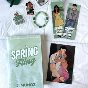 Pode incluir: Uma coleção de artigos relacionados a livros, incluindo um livro de bolso intitulado Spring Fling de J. Muñoz, dois marcadores de página com personagens, uma pulseira de contas em tons de verde, três adesivos ilustrados e uma impressão retangular.