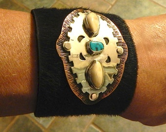 Turquoise set in sterling silver and copper on a soft fur leather cuff.