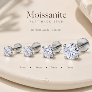 May include: Four Moissanite flat back stud earrings made of implant grade titanium. The studs are arranged in a row with sizes labelled as 3mm, 4mm, 5mm, and 6mm. Each earring features a clear, round, faceted stone set in a silver-toned metal post.