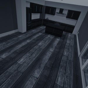 Op de afbeelding: Een keukeninterieur met donkergrijze kasten, een kookeiland en brede houten vloerplanken met een verweerde grijze afwerking. De ruimte is voorzien van witte muren, een glazen deur en inbouwverlichting voor een contrastrijk geheel.