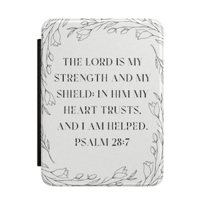 May include: A white e-reader cover featuring a black line art floral border and the text: THE LORD IS MY STRENGTH AND MY SHIELD: IN HIM MY HEART TRUSTS, AND I AM HELPED. PSALM 28:7. The cover has a textured surface and a black spine edge.
