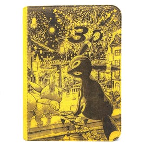 May include: A rectangular yellow and black folio case featuring a detailed illustration of two creatures, one resembling an Umbreon and one an Eevee, set against a festive night scene with fireworks and the number 30 printed in the background.