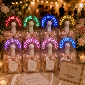 以下が含まれることがあります： THANK YOU、LOVE YOU、BEST DAY EVER、CONGRATS、MR & MRS、FOREVER、JUST MARRIED、CUSTOM TEXTと書かれたLEDファン8個。ピンクのリボンが付いた透明な箱に入っており、箱の中には紙の詰め物とサンキュータグが入っています。