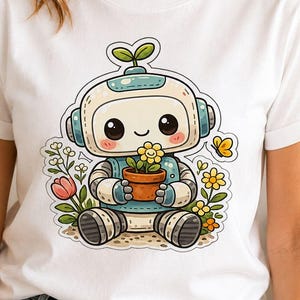 May include: A white t-shirt featuring a graphic of a small, light blue and white robot sitting down. The robot has large black eyes, pink cheeks, and a sprout on its head. It holds a brown pot with a yellow flower, surrounded by colorful flowers.