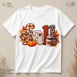 May include: A white short-sleeve t-shirt featuring the word fall in large decorative letters. The letters include orange plaid with a bow, white cable knit, and leopard print patterns. An orange pumpkin and a coffee cup are included.