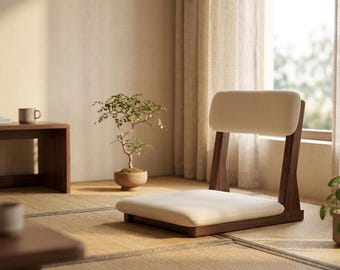 May include: A floor chair featuring a dark brown wooden frame and a cream-colored upholstered seat and backrest. The chair is designed for low-level seating and has a simple, structural form with a rectangular base and a vertical back support.