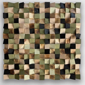 Könnte beinhalten: Ein quadratisches Wandkunstwerk, das aus zahlreichen kleinen, einzelnen Holzblöcken in einem Raster besteht. Die Blöcke weisen unterschiedliche Tiefen auf und sind in einer Palette aus natürlicher Holzmaserung, mattem Olivgrün und Schwarz gehalten.