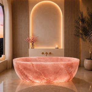Puede incluir: Una bañera ovalada independiente fabricada en piedra de cuarzo rosa translúcido con vetas naturales. La bañera presenta un acabado liso y pulido, situada en una habitación con paneles de pared de listones de madera verticales.
