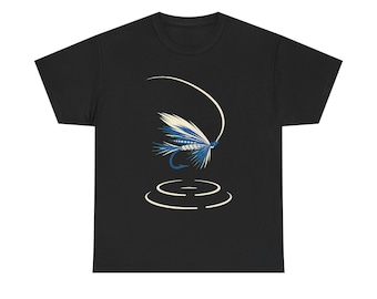 Puede incluir: Una camiseta negra de manga corta con un estampado gráfico de un señuelo de pesca con mosca en azul y blanco. El diseño incluye una línea curva sobre el señuelo y dos círculos concéntricos debajo, que sugieren ondas en el agua.