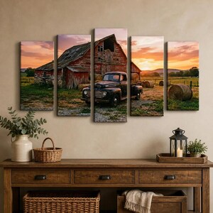 May include: A five-panel wall art set depicting a rustic red barn and a vintage black pickup truck in a field with hay bales at sunset. The scene features a warm orange and purple sky over a grassy landscape with weathered wooden structures.