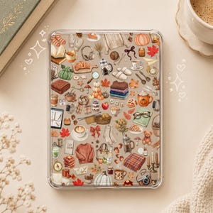 Op de afbeelding: Een doorzichtige tablethoes met een herhalend patroon van herfstachtige illustraties, waaronder pompoenen, truien, warme dranken, esdoornbladeren, boeken, kaarsen, gebak en gezellige accessoires verspreid over het gehele oppervlak van de hoes.