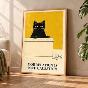 Könnte beinhalten: Ein gerahmter Kunstdruck mit einer schwarzen Katze mit gelben Augen, die ihre Pfoten auf einen hellen Schreibtisch stützt. Unter dem Schreibtisch liegt ein zerbrochenes Glas auf dem Boden. Der Hintergrund ist gelb und der Text lautet: CORRELATION IS NOT CAUSATION.
