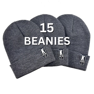 May include: Three gray knit beanies with a black leather patch that says "K Est. '89" on each. The beanies are stacked on top of each other and the text "15 BEANIES" is written in white on a black background.
