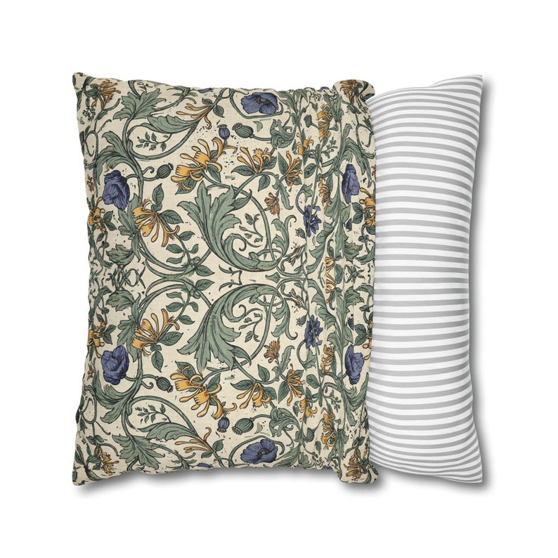 Two square pillows are displayed side by side, one showing the front botanical vine print and the other showing a gray and white striped back.