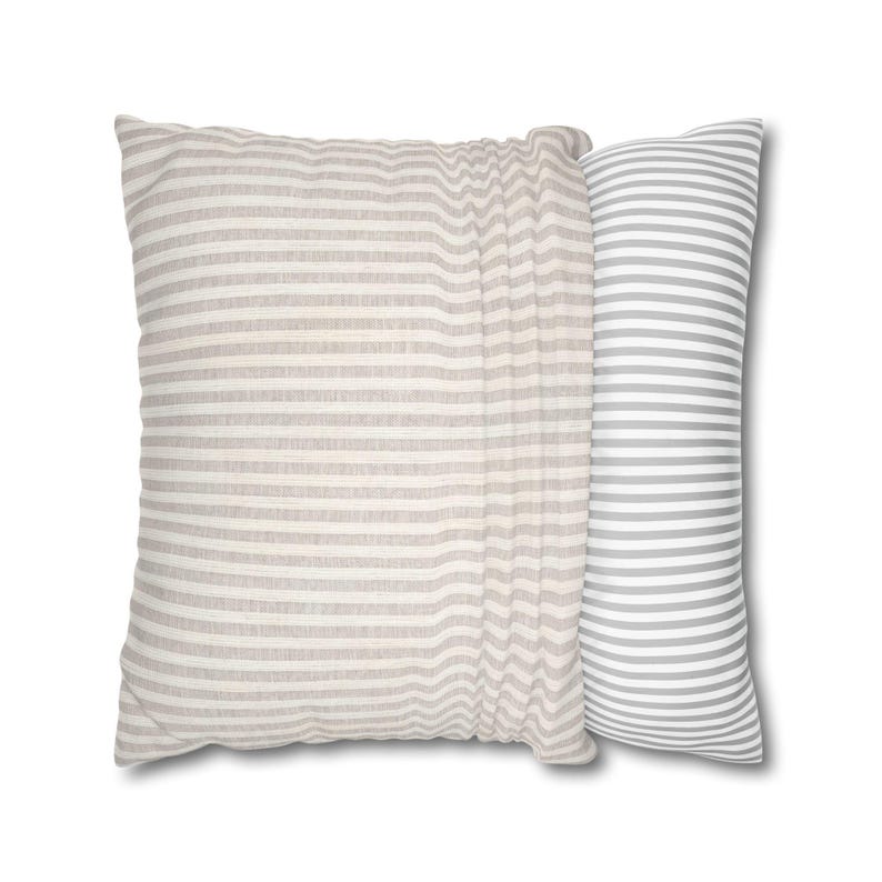 Two square pillows on a white background, one featuring vertical beige stripes and the other with horizontal grey stripes.