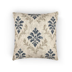 Woven indigo damask tapestry throw pillow on a plain white background, showing blue and tan damask motifs on warm ivory.