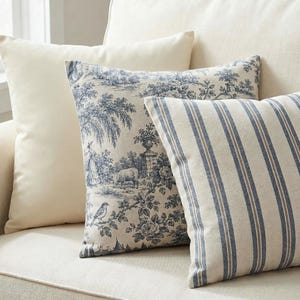 Close-up of the pillow cover set: smooth solid ivory, blue toile and blue ticking stripe printed covers