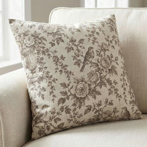 Close-up of the taupe bird and rose toile de Jouy pillow cover showing the songbird and rose print