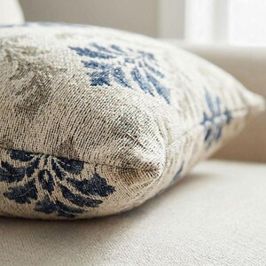 Macro close-up of the woven indigo damask tapestry pillow showing raised woven threads and the sewn edge