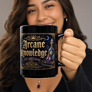 May include: A black ceramic mug featuring a gold and purple graphic design with the text Arcane Knowledge, Seek, Learn, Master. The illustration includes two glass potion bottles, stacked books, and intricate scrollwork on a dark background.