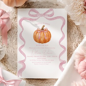 May include: A white rectangular baby shower invitation card featuring a watercolor orange pumpkin with a pink bow, framed by a pink ribbon illustration. The text reads A LITTLE PUMPKIN IS ON THE WAY, Olivia Vance, Saturday, February 23, 2058, 12:00-5:00 PM, MAYA'S HOME, 742 Willow Avenue, New York, NY 10028, RSVP to MAIVE at 225-019-2038, Register: Amazon & Target.