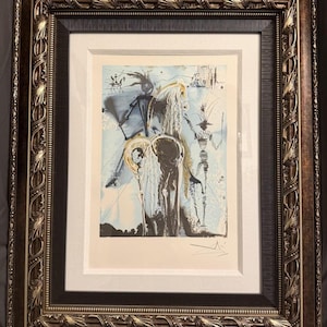 Könnte beinhalten: Ein gerahmter Druck mit einer surrealistischen Illustration eines Pferdes und Figuren in Schwarz-, Weiß- und Hellblautönen. Das Kunstwerk befindet sich in einem cremefarbenen Passepartout und einem verzierten, dunkelbronzenen Rahmen mit Blattmustern.