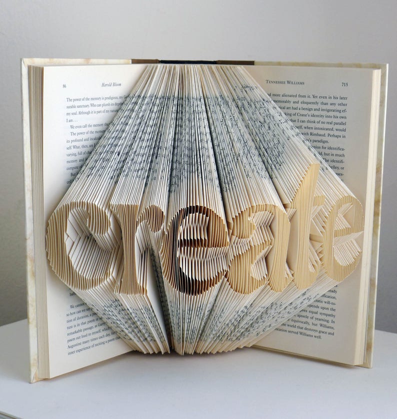 K&ouml;nnte beinhalten: Ein Buch mit dem Wort "create" in die Seiten gefaltet. Das Buch ist ge&ouml;ffnet und die Seiten sind gefaltet, um das Wort in 3D zu erstellen.