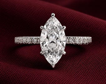 May include: A silver-toned ring featuring a large marquise-cut center stone held by six prongs. The band is encrusted with small round pavé-set stones along the shank. The text CAREIO is visible on the right side of the ring band.