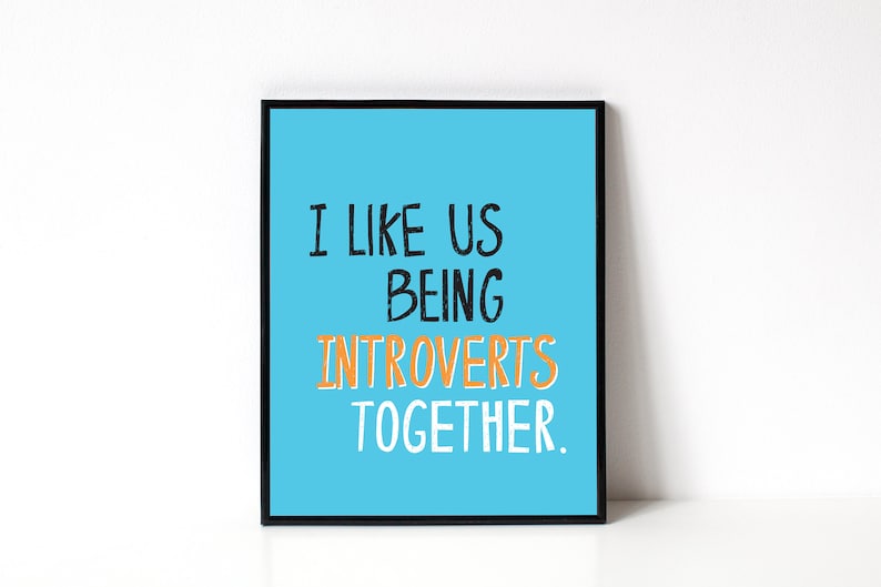 May include: A framed print with a light blue background and white text that reads "I like us being introverts together." The word "introverts" is in orange.