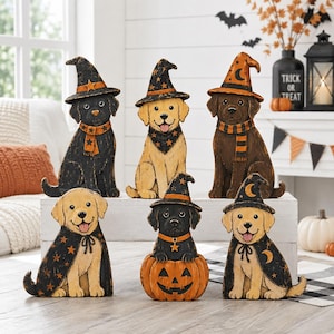 May include: Six wooden dog figurines featuring black, yellow, and chocolate Labrador retrievers dressed in Halloween costumes. The dogs wear pointed witch hats, capes, and scarves decorated with stars, moons, and stripes. One dog sits inside a pumpkin.