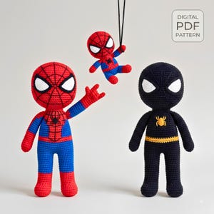 May include: Three crocheted dolls representing superhero characters. One large red and blue doll with a web pattern, one small hanging red and blue doll, and one large black doll with a yellow spider emblem. Includes a digital PDF pattern label.