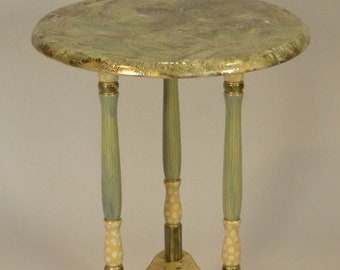 May include: A small, round, green and gold painted side table with three legs. The table top has a marbled design and the legs are painted with white polka dots.