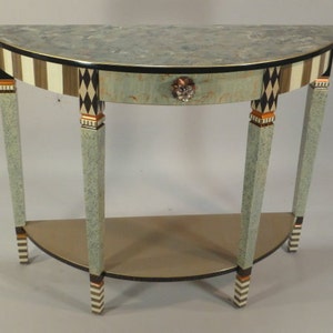 May include: A half-round table with a light blue painted finish and black and white striped legs. The table has a single drawer with a decorative knob and a lower shelf.