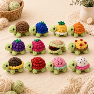 May include: A collection of twelve small, crocheted turtle figurines arranged in three rows. Each turtle has a light green body with black bead eyes and a unique, textured shell resembling various fruits, berries, and patterns in vibrant colors.