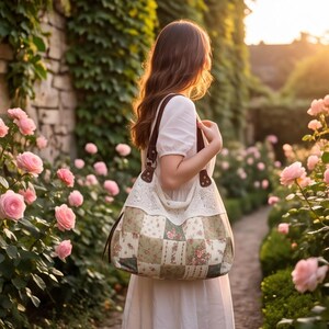 May include: A shoulder bag featuring a patchwork design with floral and striped patterns in muted green, red, and cream tones. The bag includes a white lace trim along the top edge and dark brown leather straps attached with metal rings.