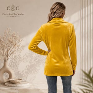 Women’s polyester velvet cardigan in ivory with decorative gold buttons, long sleeves, and a mid-length elegant design.