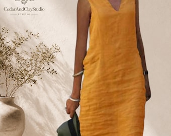 May include: A sleeveless mustard yellow knee-length dress with a V-neckline. The dress features a simple, straight-cut silhouette and is made of a textured fabric. The CedarAndClayStudio logo is visible in the upper left corner of the image.