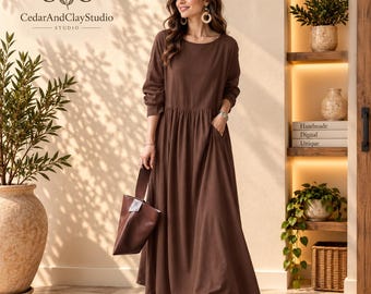 May include: A long-sleeved, floor-length brown dress with a round neckline and a gathered waistline. The dress features side pockets and is paired with a matching brown handbag. The CedarAndClayStudio logo is visible in the upper left corner.