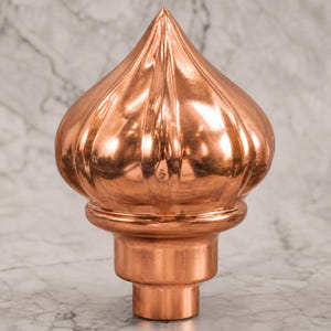 May include: A polished copper finial featuring a bulbous, onion-shaped top with vertical fluted ridges. The decorative piece has a smooth, reflective metallic surface and a cylindrical base designed for mounting, showcasing a warm, reddish-brown tone.