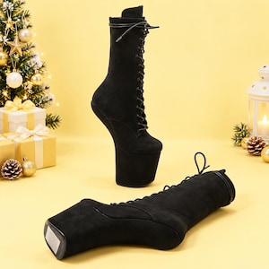 May include: A pair of black suede boots featuring a high platform sole and a stiletto heel. One boot stands upright while the other lies horizontally. Both boots have a lace-up front closure with black laces extending up the calf-high shaft.
