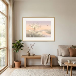May include: A framed horizontal wall art print featuring a soft-toned landscape illustration of white spider lilies in the foreground, a winding river, and a small red dragonfly in the sky, all set against a pale, hazy, pastel-colored background.