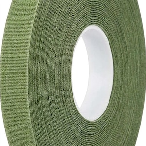 May include: A roll of olive green floral tape with a textured, matte surface. The tape is wound around a white plastic circular core, showing a consistent width and a slightly fibrous, paper-like appearance throughout the entire roll.