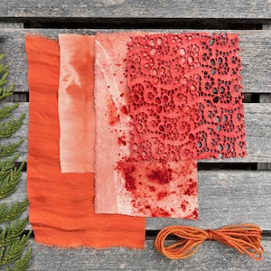 Peut inclure: Divers échantillons de tissus orange et une pelote de fil orange sur une surface en bois. Les tissus présentent des textures et motifs variés, avec des nuances d'orange et de rouge-orangé. Le fil est soigneusement enroulé.