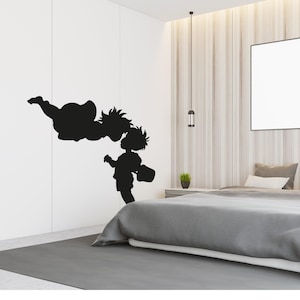 May include: A black wall decal featuring a silhouette of a flying figure with spiky hair reaching towards a smaller standing figure with spiky hair who is holding a bucket. The design is composed of solid black shapes against a white wall.