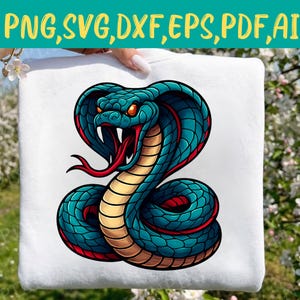 Könnte beinhalten: Ein weißes Sweatshirt mit einer grafischen Illustration einer zusammengerollten Kobra mit türkisfarbenen Schuppen, cremefarbenem Bauch, leuchtend orangen Augen und offenem Maul mit roter Zunge. Der Text PNG, SVG, DXF, EPS, PDF, AI steht oben.