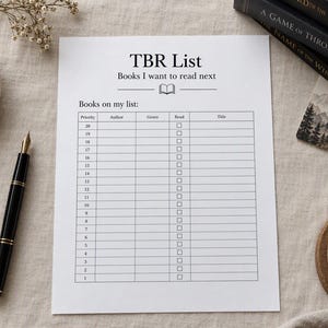 Puede incluir: Una hoja de papel blanca TBR List con el encabezado Books I want to read next, que presenta una tabla con columnas para Priority, Author, Genre, Read y Title, junto a una pluma estilográfica negra y libros.