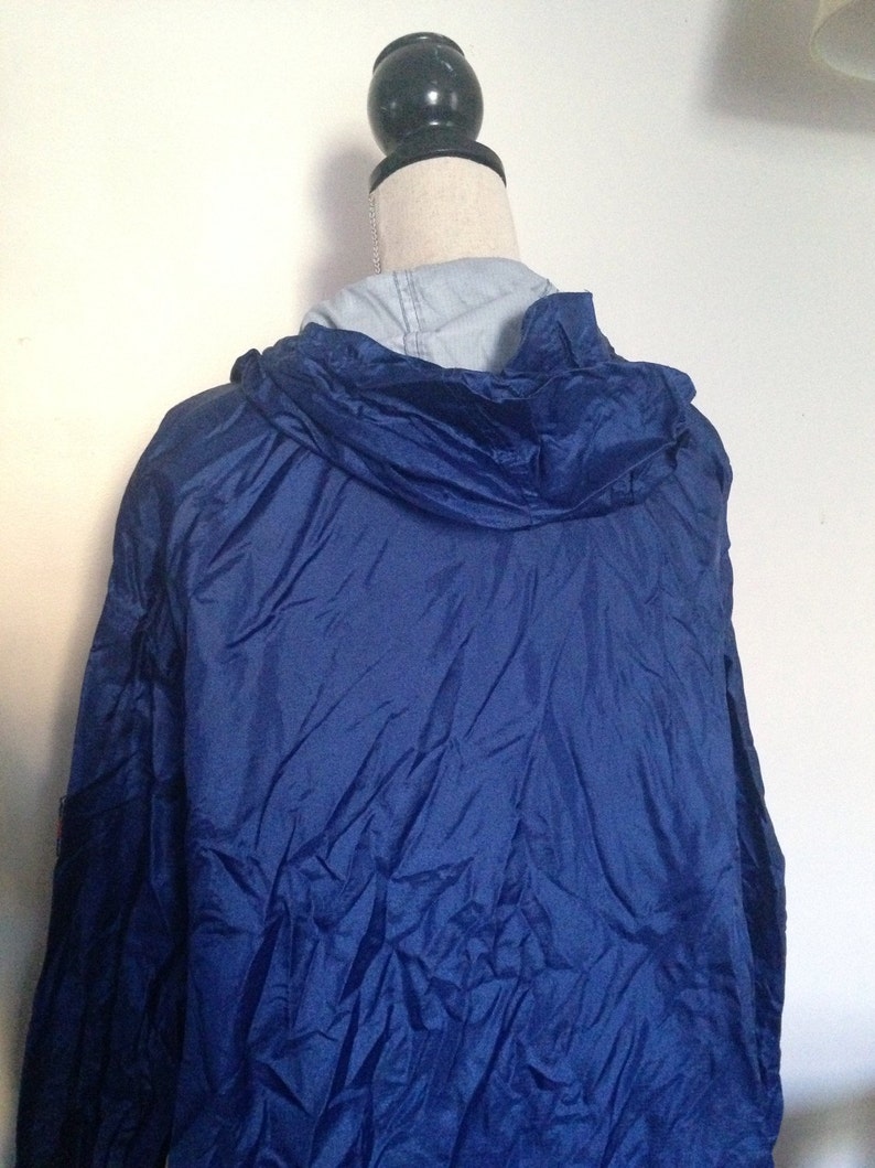 May include: A blue hooded jacket with a zipper closure. The jacket is made of a lightweight, water-resistant material.